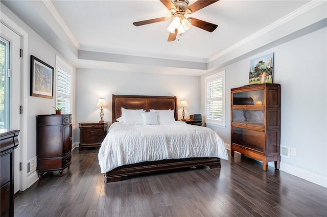 bedroom featuring a raised ceiling, dark wood-style floors, ornamental molding, baseboards, and ceiling fan