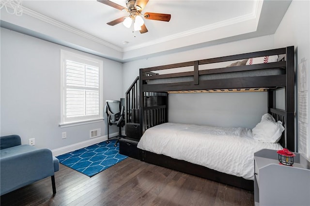 bedroom featuring hardwood / wood-style floors, baseboards, crown molding, and a ceiling fan