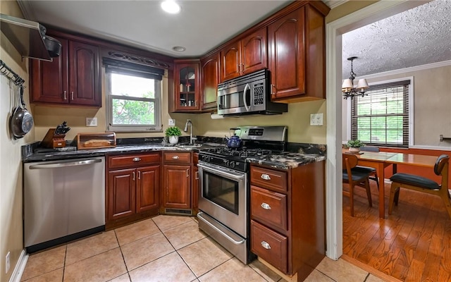 811 Jefferson Dr, Ross Twp, PA 15229 - kitchen with appliances with stainless steel finishes, plenty of natural light, crown molding, a chandelier, and glass insert cabinets