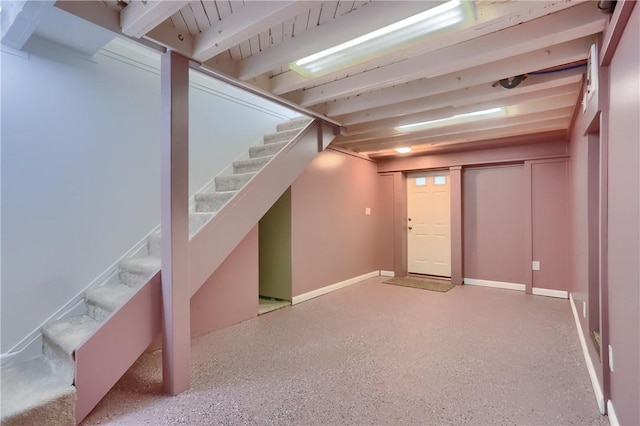 finished below grade area featuring stairway and baseboards