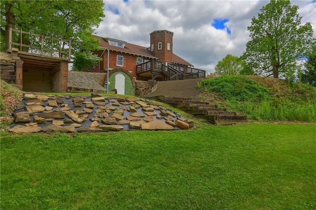 view of grassy yard featuring stairway and a wooden deck