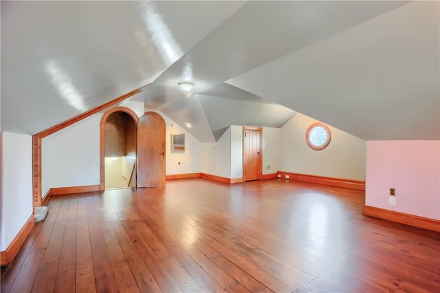 bonus room with baseboards, hardwood / wood-style flooring, and lofted ceiling