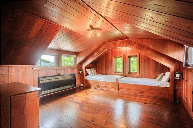 unfurnished bedroom with radiator, wood-type flooring, wooden walls, vaulted ceiling, and wood ceiling