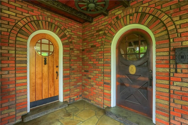 view of exterior entry featuring brick siding