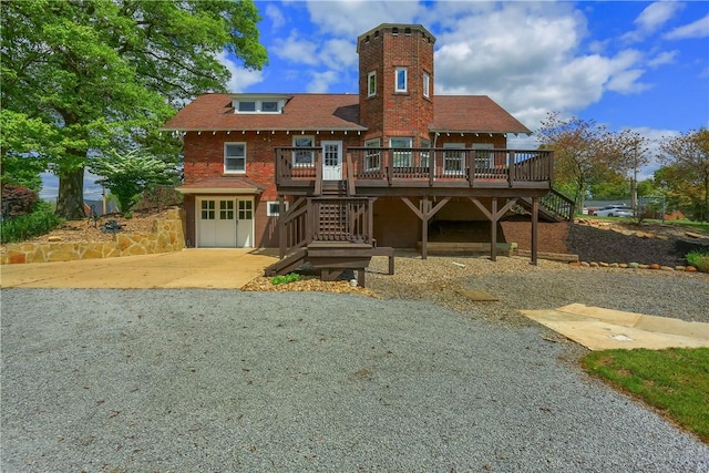 view of front of house featuring stairs, concrete driveway, an attached garage, and a wooden deck