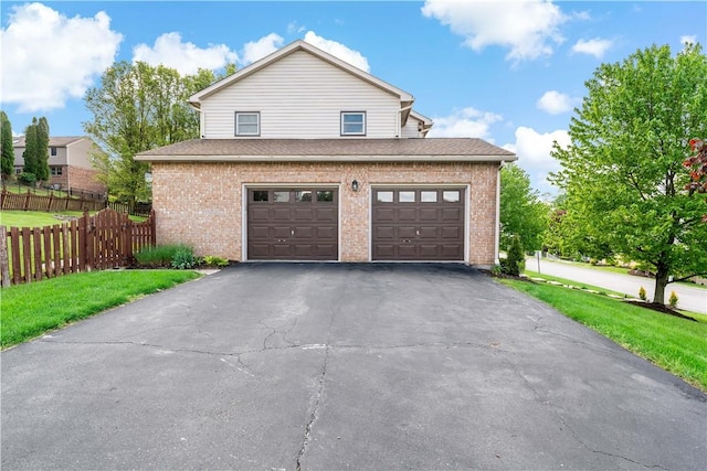 view of front of home with asphalt driveway, brick siding, and an attached garage