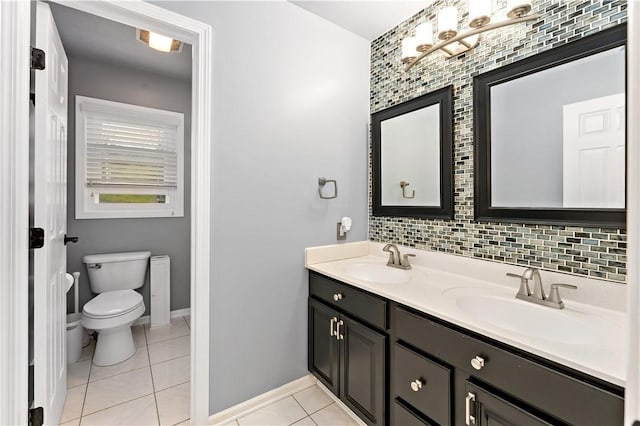 full bath featuring toilet, tile patterned floors, baseboards, decorative backsplash, and double vanity