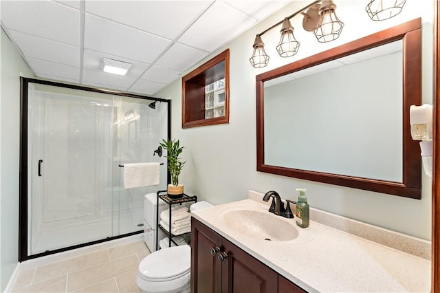 full bathroom with a shower stall, toilet, vanity, tile patterned floors, and a paneled ceiling