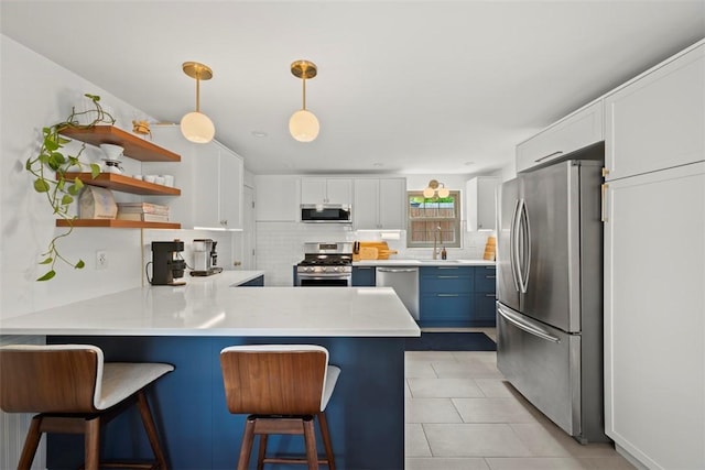 665 Dunster St, Brookline, PA 15226 - kitchen featuring appliances with stainless steel finishes, a peninsula, decorative backsplash, light countertops, and a sink