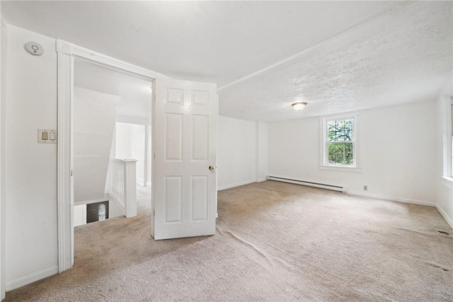 unfurnished bedroom featuring baseboard heating, carpet flooring, and baseboards