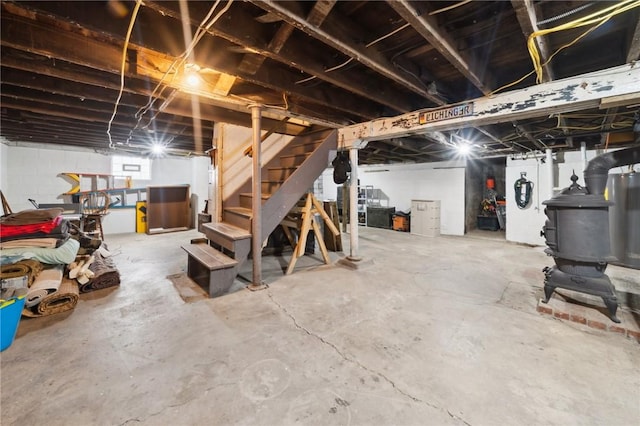 below grade area featuring stairs and a wood stove