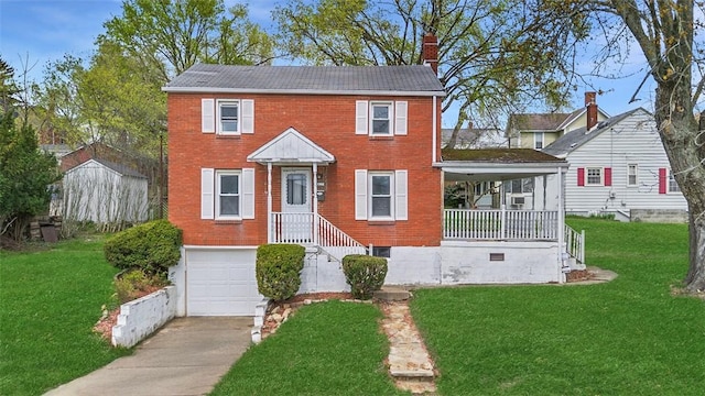 colonial house featuring a garage, driveway, a front yard, brick siding, and a chimney