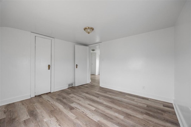 unfurnished bedroom with wood finished floors and baseboards