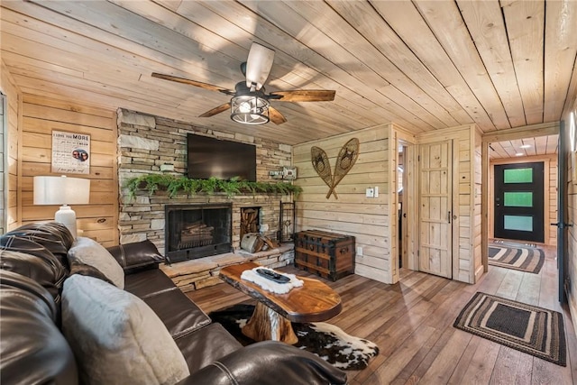 133 Imperial Rd, Hidden Valley, PA 15502 - living room with wood ceiling, wooden walls, ceiling fan, hardwood / wood-style flooring, and a stone fireplace