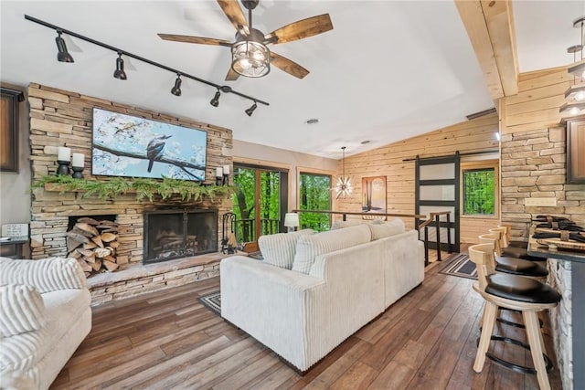 133 Imperial Rd, Hidden Valley, PA 15502 - living area with rail lighting, a fireplace, wooden walls, vaulted ceiling, and hardwood / wood-style floors