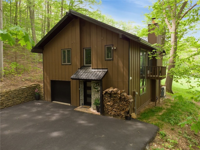 133 Imperial Rd, Hidden Valley, PA 15502 - view of home's exterior featuring driveway, a chimney, an attached garage, and board and batten siding