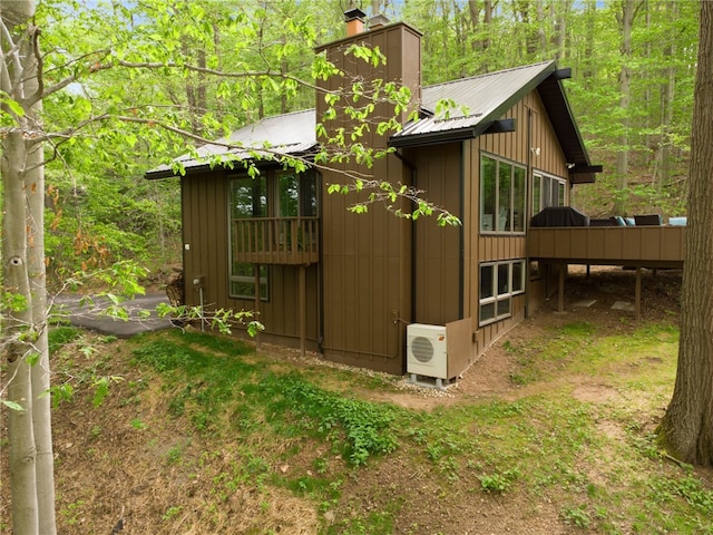 133 Imperial Rd, Hidden Valley, PA 15502 - view of side of home with a metal roof, a chimney, board and batten siding, a deck, and a wooded view