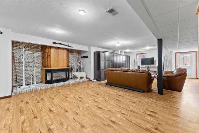 844 Old Millcreek Rd, Hookstown, PA 15050 - living room featuring light wood-type flooring, a textured ceiling, baseboards, and a glass covered fireplace