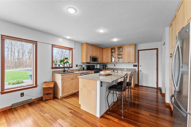 844 Old Millcreek Rd, Hookstown, PA 15050 - kitchen with appliances with stainless steel finishes, a sink, a kitchen breakfast bar, wood finished floors, and recessed lighting