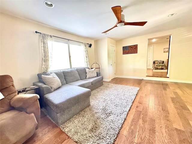 living room with light wood-type flooring, a ceiling fan, baseboards, and recessed lighting