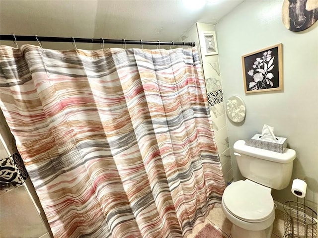 bathroom with toilet, tile patterned floors, and curtained shower