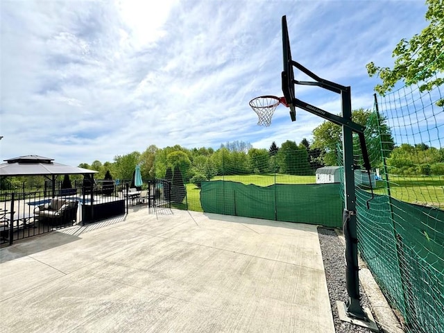 view of patio / terrace featuring a gazebo, fence, and community basketball court