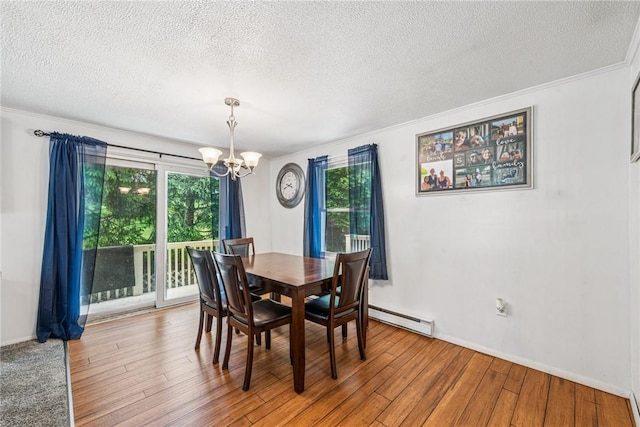 716 Stauffer Ave, Scottdale, PA 15683 - dining space with a baseboard heating unit, a chandelier, wood finished floors, a textured ceiling, and ornamental molding