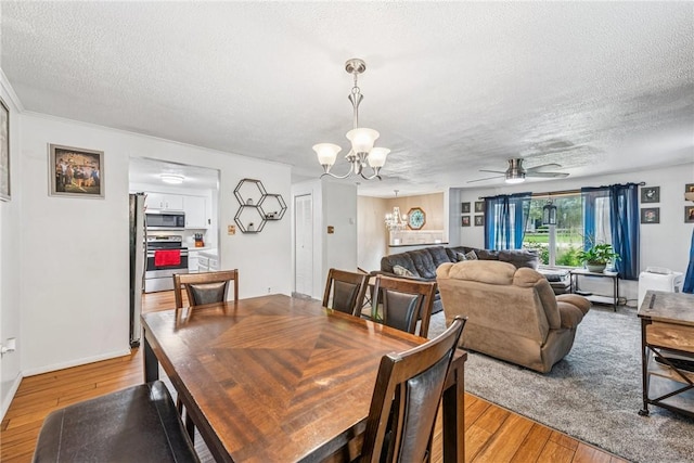 716 Stauffer Ave, Scottdale, PA 15683 - dining area featuring a textured ceiling, light wood finished floors, a chandelier, and a ceiling fan