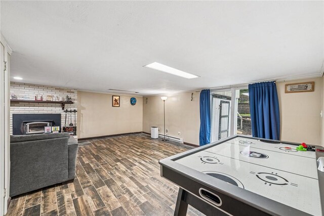 716 Stauffer Ave, Scottdale, PA 15683 - game room with wood finished floors, ornamental molding, baseboards, a brick fireplace, and a baseboard heating unit