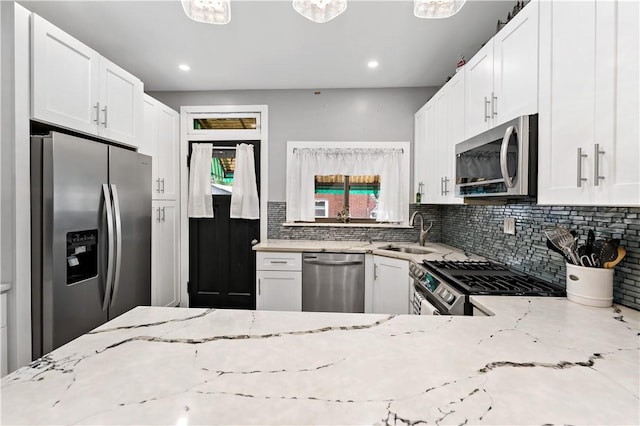 53 Sycamore St, Etna, PA 15223 - kitchen featuring appliances with stainless steel finishes, a sink, light stone counters, backsplash, and white cabinets