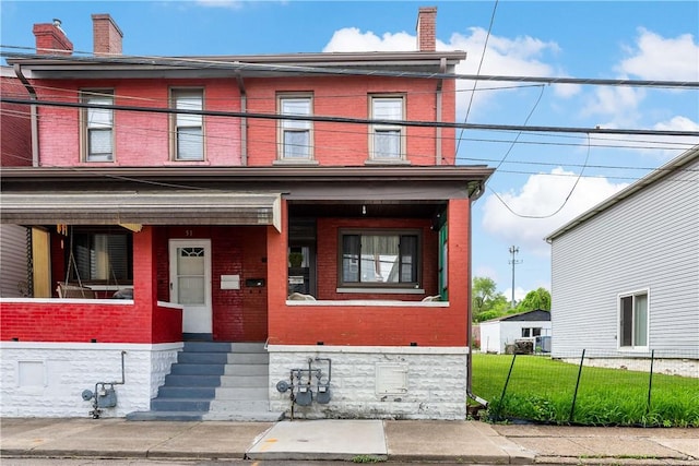 53 Sycamore St, Etna, PA 15223 - view of front of house with brick siding, covered porch, a balcony, fence, and a chimney