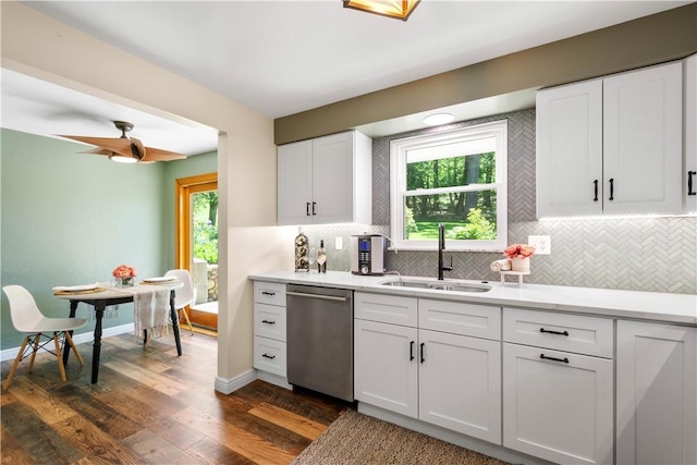 kitchen featuring stainless steel dishwasher, a sink, decorative backsplash, and dark wood-style flooring