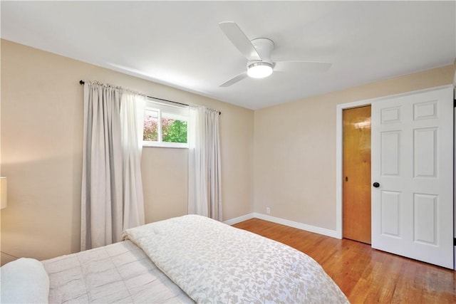 bedroom with wood finished floors, baseboards, and a ceiling fan