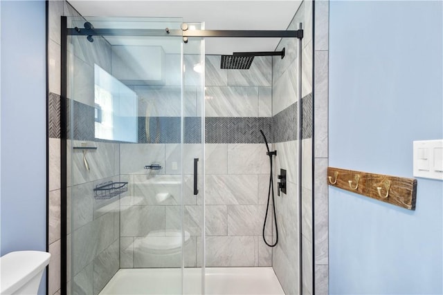 bathroom featuring toilet and a stall shower