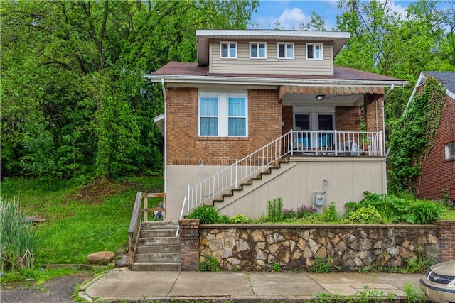 view of front of home with stairway, brick siding, and a porch
