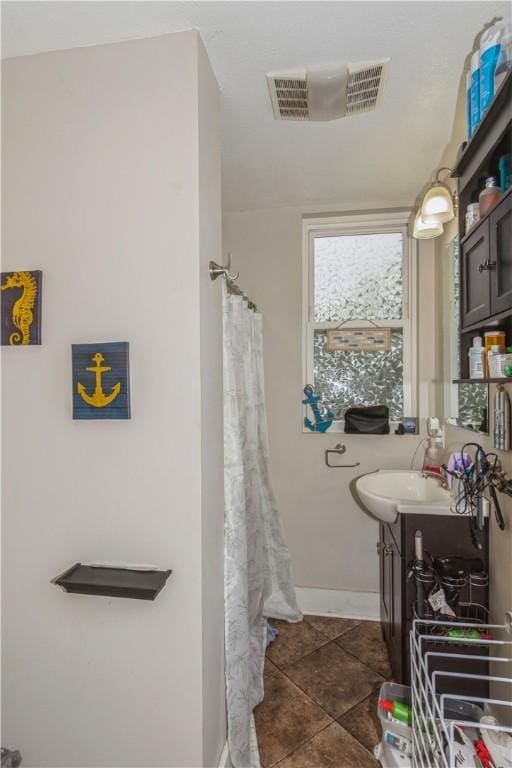 bathroom featuring vanity, tile patterned flooring, baseboards, and a shower with shower curtain