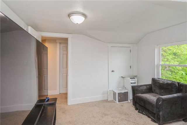 living area with light colored carpet, vaulted ceiling, and baseboards