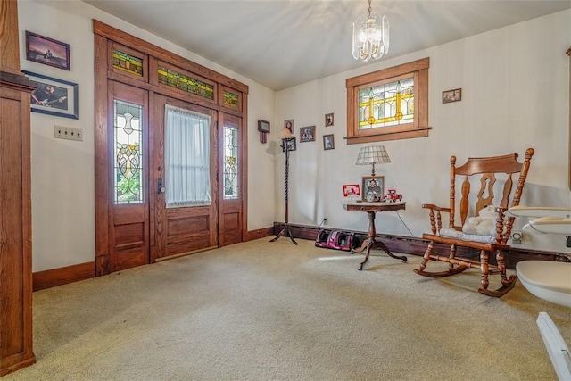 entrance foyer with plenty of natural light, carpet flooring, a chandelier, and baseboards
