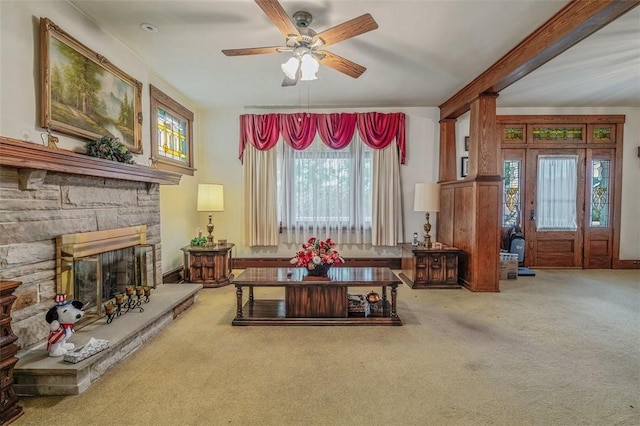 living area featuring a ceiling fan, a fireplace, and carpet