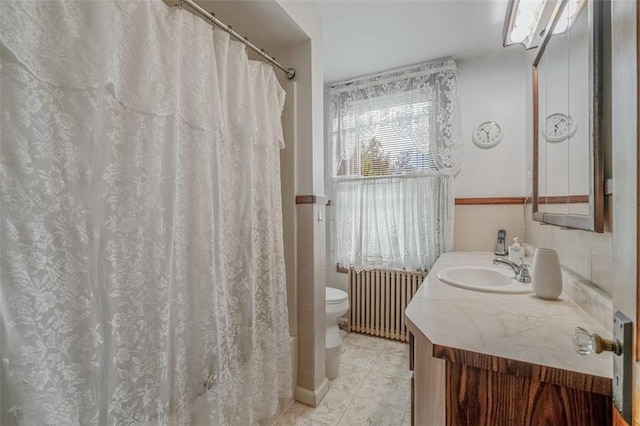 bathroom featuring radiator heating unit, toilet, vanity, and tile patterned floors