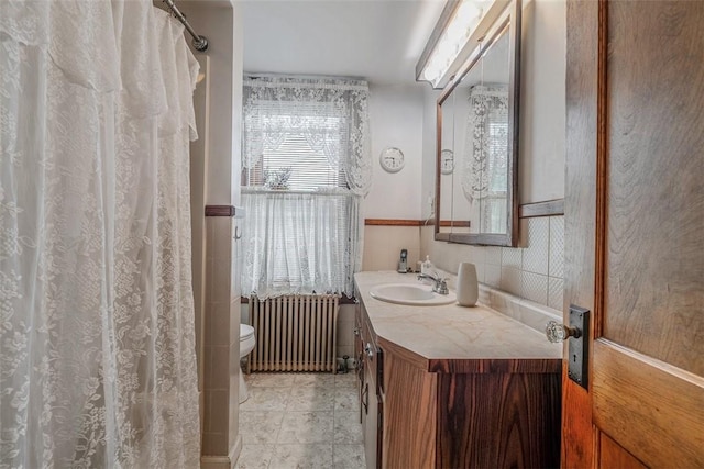 bathroom with radiator heating unit, toilet, vanity, and a shower with curtain