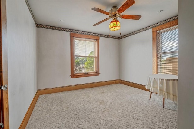 carpeted spare room with baseboards and ceiling fan