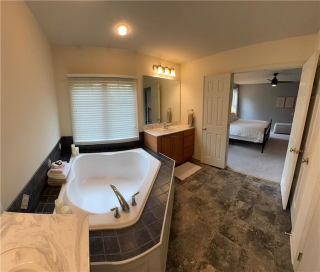 bathroom featuring connected bathroom, a bath, vanity, stone finish floors, and ceiling fan