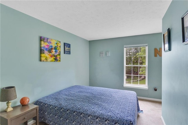 carpeted bedroom featuring baseboards and a textured ceiling