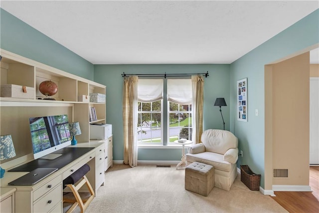 office space featuring baseboards and light colored carpet