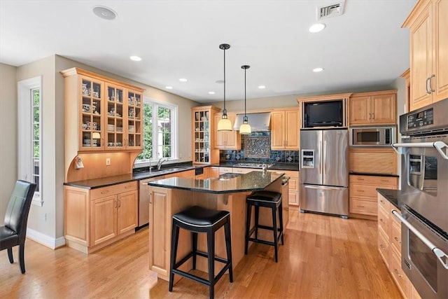 305 Woodstream Dr, Ohara, PA 15238 - kitchen featuring appliances with stainless steel finishes, light wood finished floors, tasteful backsplash, a kitchen breakfast bar, and glass insert cabinets