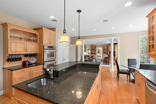 305 Woodstream Dr, Ohara, PA 15238 - kitchen with stainless steel appliances, a sink, a center island with sink, light brown cabinetry, and ornate columns
