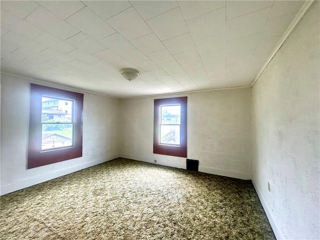 carpeted empty room featuring ornamental molding and baseboards