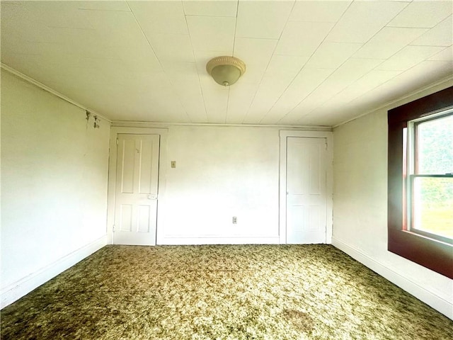 carpeted spare room featuring baseboards