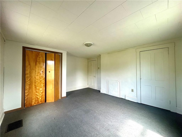 unfurnished bedroom featuring baseboards and dark colored carpet